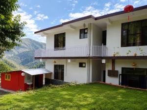 a house with a green lawn in front of it at The Sanctuary in McLeod Ganj +10 photos