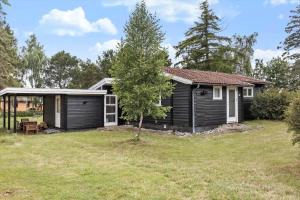 a small black house with a yard at 1102-Stege-Rylevej-24 in Stege