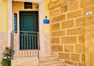 a building with a green door and a balcony at Sun Apartments in Agrigento