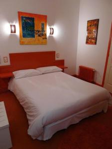 ein Schlafzimmer mit einem großen weißen Bett in einem Zimmer in der Unterkunft Hôtel Le Coin des Halles in Cahors