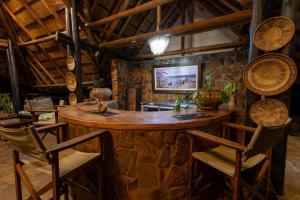 a bar in a room with a stone wall at Masuwe Lodge in Victoria Falls