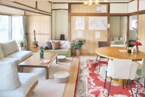 a living room with a couch and a table at 宇都宮ゲストハウス花ニ嵐 Guesthouse Hana ni Arashi in Utsunomiya