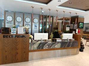 a reception counter in a store with clocks on the wall at Sam Hotel in Antalya +73 photos