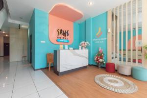 a lobby with a star trader sign on the wall at Sans Hotel Good Wish Semarang in Jomblang