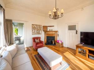 a living room with a couch and a tv at Crescent Villa - Stay Waiheke in Ostend +18 photos