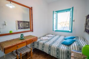 a bedroom with a bed with blue pillows and a mirror at Villa Pitini in Symi +36 photos
