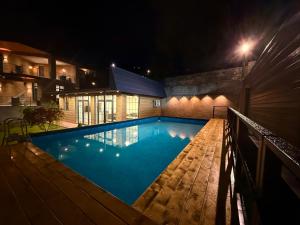 a swimming pool at night next to a building at Mountain Symphony Cottage Dilijan in Dilijan