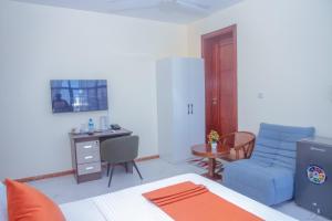 a bedroom with a bed and a desk and a chair at Andrew View Hotel in Dar es Salaam