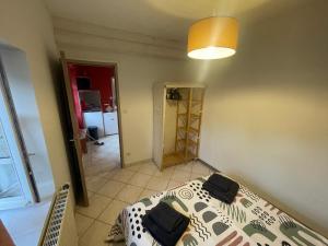 a bedroom with a bed and a lamp and a hallway at Chez KUD in Bourbon-Lancy