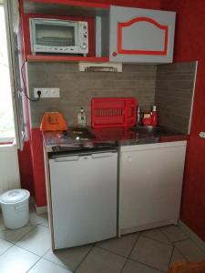 a small kitchen with a stove and a microwave at Chez KUD in Bourbon-Lancy