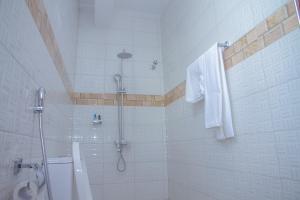 a white bathroom with a shower and a toilet at Andrew View Hotel in Dar es Salaam +124 photos