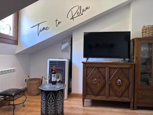 a living room with a tv and a entertainment center at El Rincon de Carmen in Felechosa