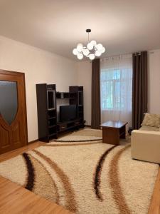 a living room with a couch and a television at Солнышко VIP 1 in Chok-Tal