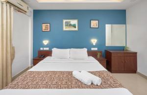 a blue bedroom with a bed with two towels on it at North Centre in Cochin +102 photos