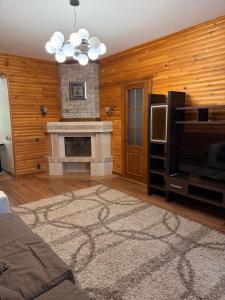 a living room with a fireplace and a television at Солнышко VIP 1 in Chok-Tal