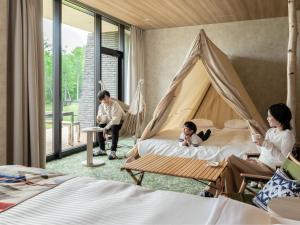 a family in a bedroom with a tent at Kiyosato Kogen Resort in Hokuto