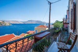 a balcony with a bench and a view of the water at Villa Pitini in Symi