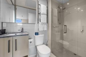 a white bathroom with a toilet and a shower at MainStay Suites Hawthorn in Hawthorn +60 photos