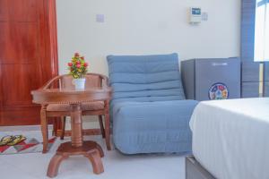 a bedroom with a table and a blue couch at Andrew View Hotel in Dar es Salaam
