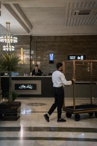 a man pushing a luggage cart in a hotel lobby at Helmond Hotel in Erbil +116 photos
