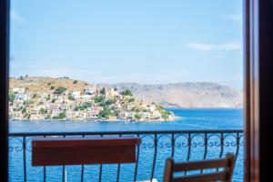 a balcony with a view of a town on the water at Villa Pitini in Symi