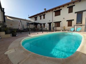 a swimming pool in front of a building at Casa Rural Villa Cárcavas in Maello
