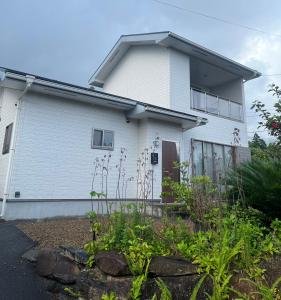 a white house with a garden in front of it at ココナッツ屋久島 in Yakushima