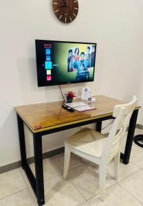 a desk with a television and a white chair at JORA Studio Apartment 1-B in Dagupan
