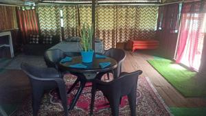 a dining room with a table and chairs and a plant at The Hojai Farmland in Hāflong