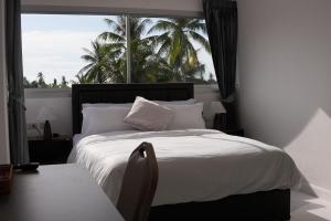 ein Schlafzimmer mit einem Bett und einem großen Fenster in der Unterkunft Keya hotel samui in Plai Laem