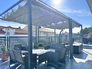 a patio with a table and chairs under an umbrella at Sunrise Villa Lopar in Lopar