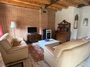 ein Wohnzimmer mit zwei Sofas und einem Fernseher in der Unterkunft La Salceda in Torre Val de San Pedro