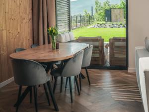 a dining room with a wooden table and chairs at Miło Tu - Stodoła pod Karpaczem in Miłków +23 photos