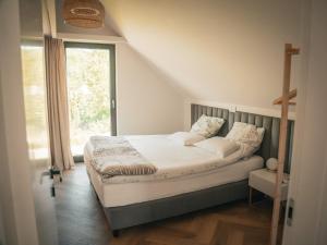 a bedroom with a bed and a window at Miło Tu - Stodoła pod Karpaczem in Miłków
