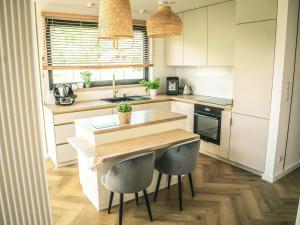 a kitchen with a wooden table and two stools at Miło Tu - Stodoła pod Karpaczem in Miłków