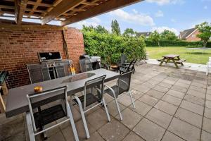 a patio with a table and chairs and a grill at 4231-Stege-Nymarksvej-21 in Stege