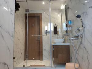 a bathroom with a shower with a sink and a toilet at Eennra Ssubarna in Baharampur +29 photos