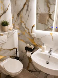 a bathroom with a white toilet and a sink at Ferienhaus im Wiesengrund in Simmerath