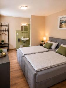 a bedroom with a large bed and a sink at Ferienhaus im Wiesengrund in Simmerath +15 photos