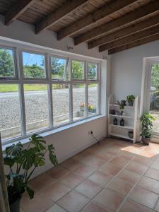 a living room with windows and a tiled floor at The Stables in Aglish
