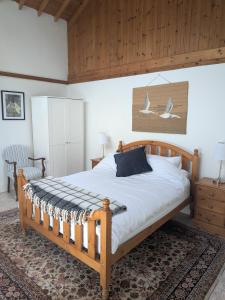 a bedroom with a large bed with a wooden frame at The Stables in Aglish
