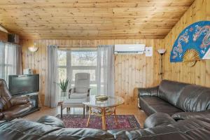 a living room with a leather couch and a table at FA058-Faxe-Ladeplads-Anders-Lassens-vej-2 in Fakse Ladeplads