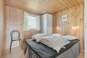 a bedroom with a bed and a chair in it at FA058-Faxe-Ladeplads-Anders-Lassens-vej-2 in Fakse Ladeplads