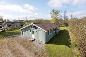 a small green building on a grass field at FA058-Faxe-Ladeplads-Anders-Lassens-vej-2 in Fakse Ladeplads