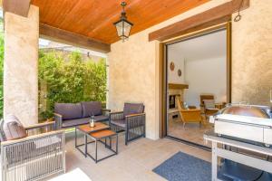 an outdoor patio with furniture and a piano at La Villa D'antan - Piscine in Nyons