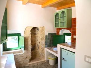 a kitchen with green cabinets and a stone wall at Case Vacanza Al Borgo Antico in Vico del Gargano +112 photos