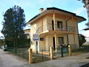 a house with a balcony and a fence at Luca in Bibione
