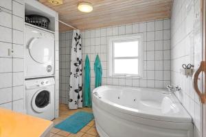 a bathroom with a tub and a washing machine at 1319-Thisted-Store-Knuds-Vej-9 in Thisted +11 photos