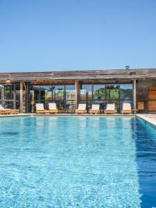 a swimming pool with lounge chairs on a building at Lodges en Provence - Ecogîtes & Restaurant insolites in Richerenches