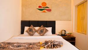 a bed with a black headboard in a bedroom at River Town Stays in Varanasi